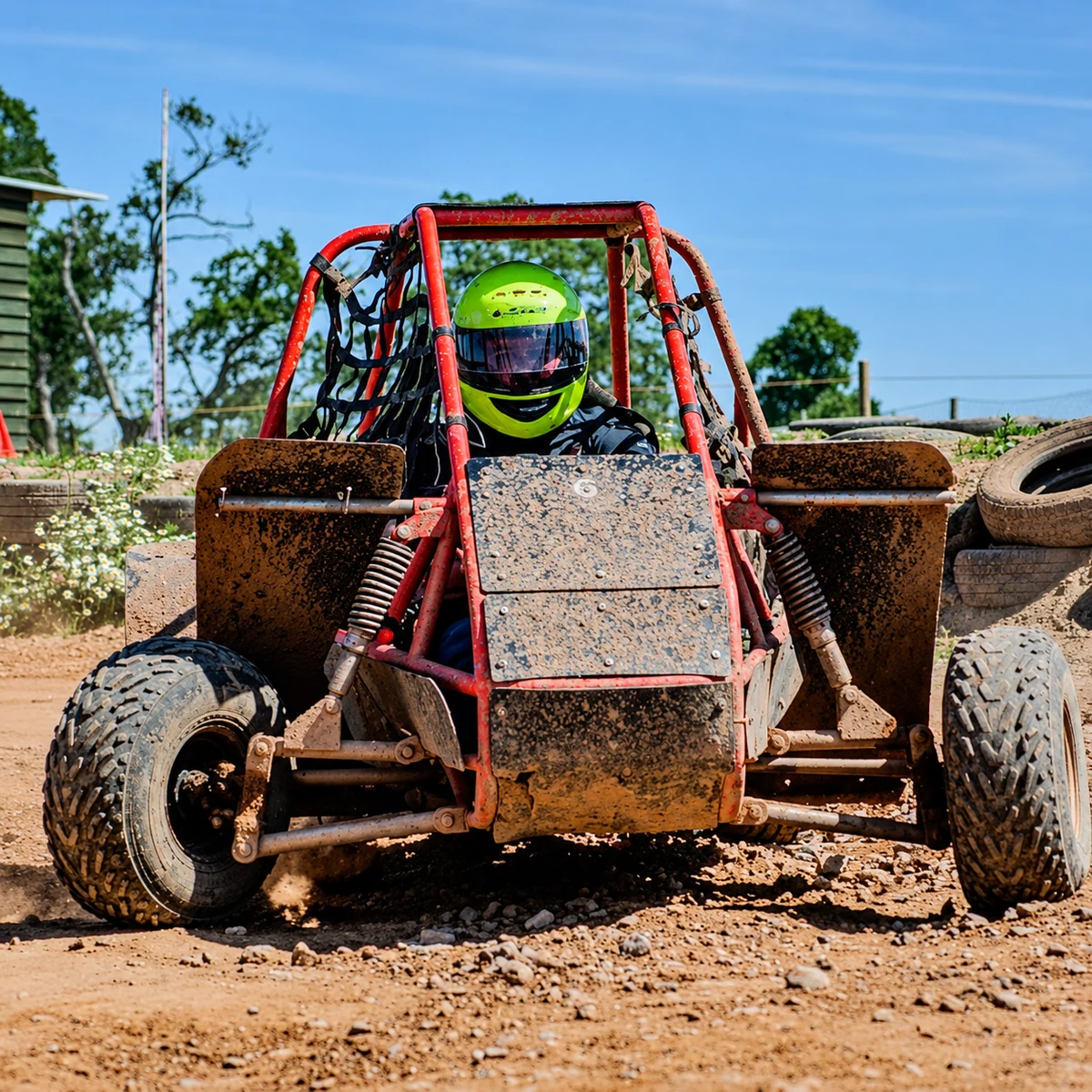 A helmeted driver in a red off-road kart at Exeter Karting